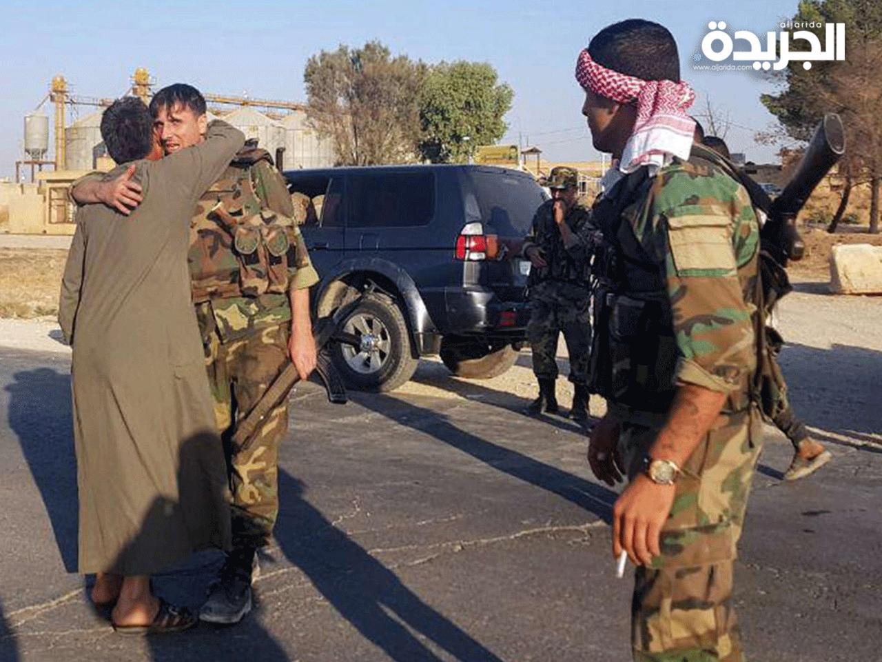 أحد سكان مدينة تل تمر يعانق جندي من قوات النظام السوري بعد انتشارهم في المنطقة تمر 