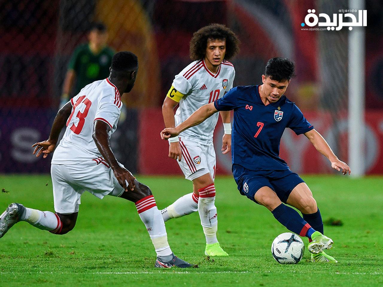 مهاجم المنتخب التايلندي يحاول الإفلات من لاعبي منتخب الإمارات