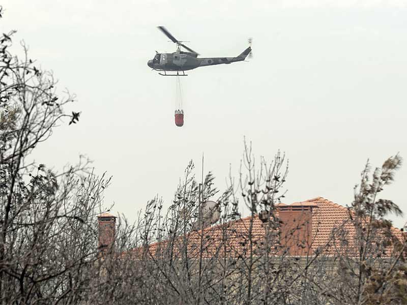 مروحية لبنانية تحاول إطفاء النيران فوق بلدة مشرف في قضاء الشوف جنوب بيروت أمس            (أ ف ب)