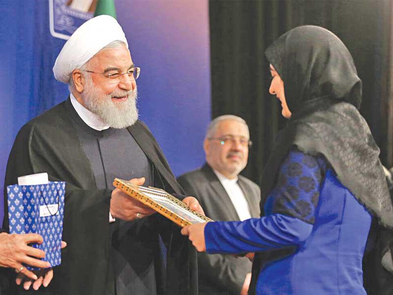 الرئيس الإيراني يكرم طالبة بمناسبة انطلاق العام الدراسي الجديد في طهران أمس (إرنا)n