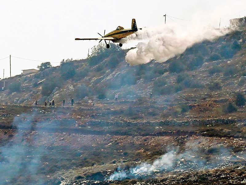 طائرة إسرائيلية ترش مواد لإخماد حريق اندلع أمس قرب مستوطنة ايتزهار شمال الضفة الغربية t(أ ف ب)n