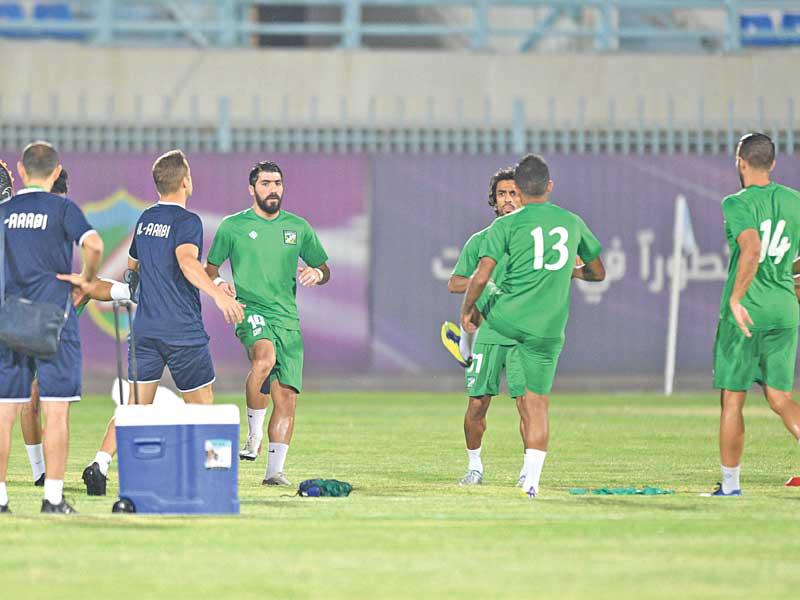 لاعبو العربي يجرون تدريبات إحماء قبل خوض مباراة سابقة