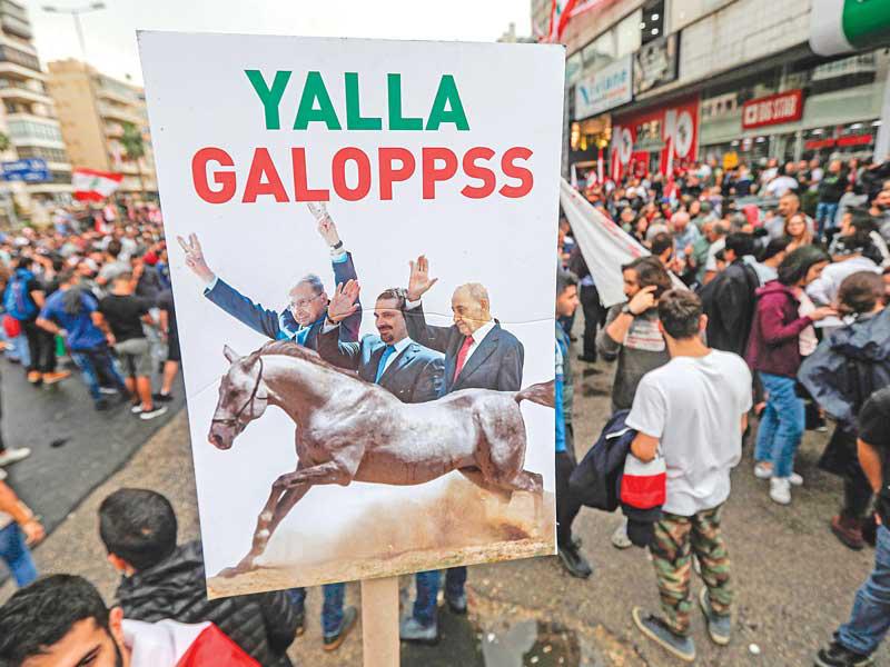 لافتة تدعو لرحيل الرؤساء الثلاثة في زوق مصبح أمس    (أ ف ب)