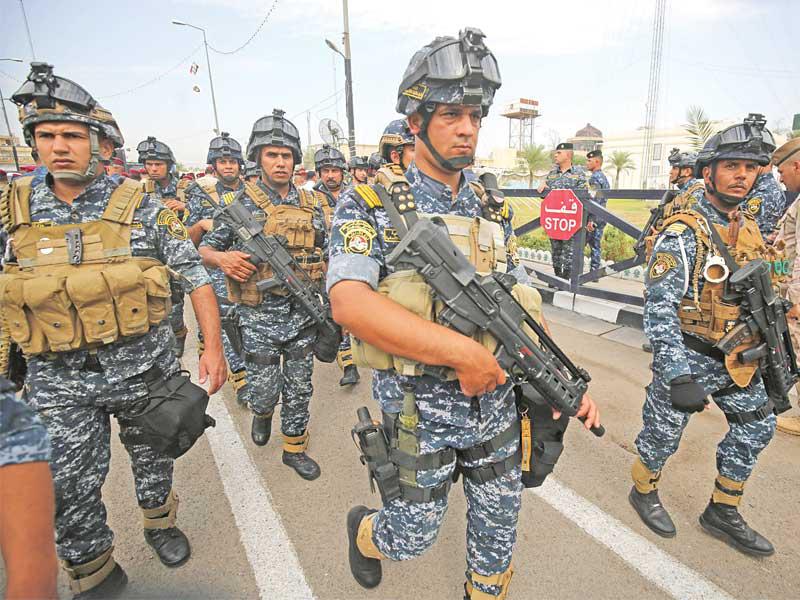 عناصر أمنية تشارك بجنازة قائد عسكري قتل في هجوم لـ«داعش» ببغداد أمس الأول (أ ف ب)