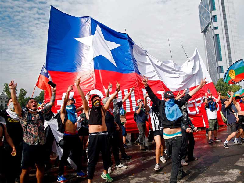 - المتظاهرون يحملون العلم التشيلي الكبير في سانتياغو في اليوم السادس على التوالي من أعمال العنف في الشوارع