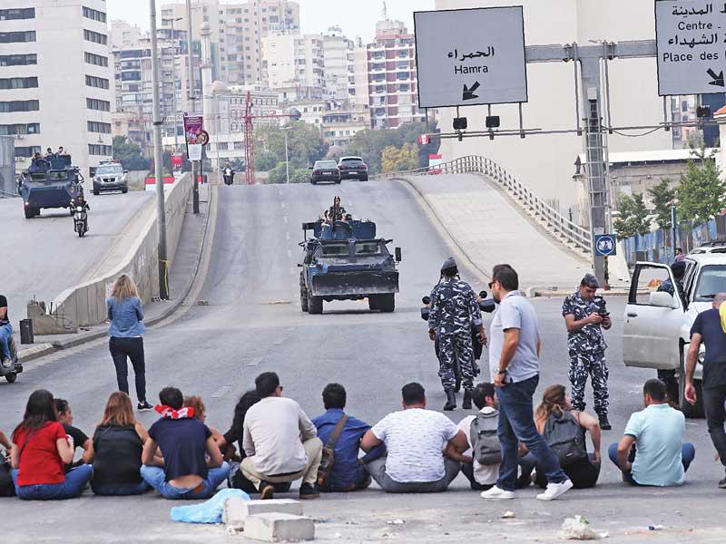 متظاهرون يسدون طريقاً على «جسر الرينغ» وسط بيروت أمس (أ ف ب)