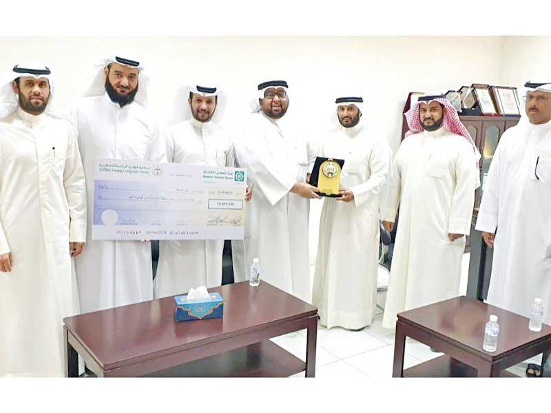 وفد «الزكاة» خلال تسلم زكاة جمعية الوفرة