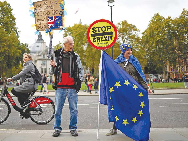 معارضان لـ«بريكست» يتظاهران أمام البرلمان في لندن أمس (رويترز)n