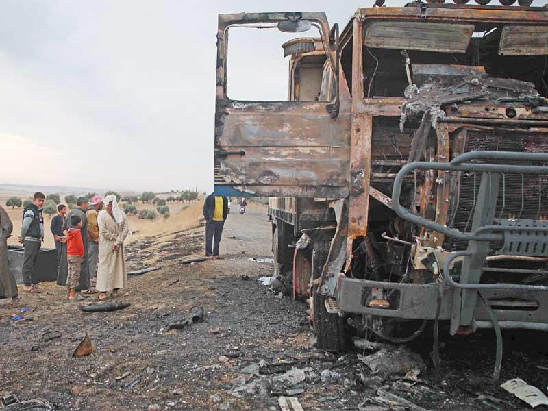 سوريون يتفقدون موقع غارة قتلت الناطق باسم «داعش» أبو حسن المهاجر قرب جرابلس أمس الأول          (أ ف ب)