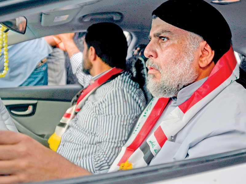 الصدر يقود سيارته لدى وصوله إلى ساحة التظاهر في النجف أمس  (أ ف ب)