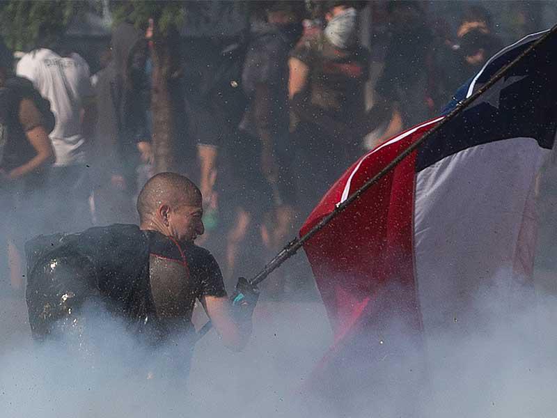 المتظاهرون اشتبكوا مع شرطة مكافحة الشغب خارج قصر لا مونيدا الرئاسي ، في سانتياغو