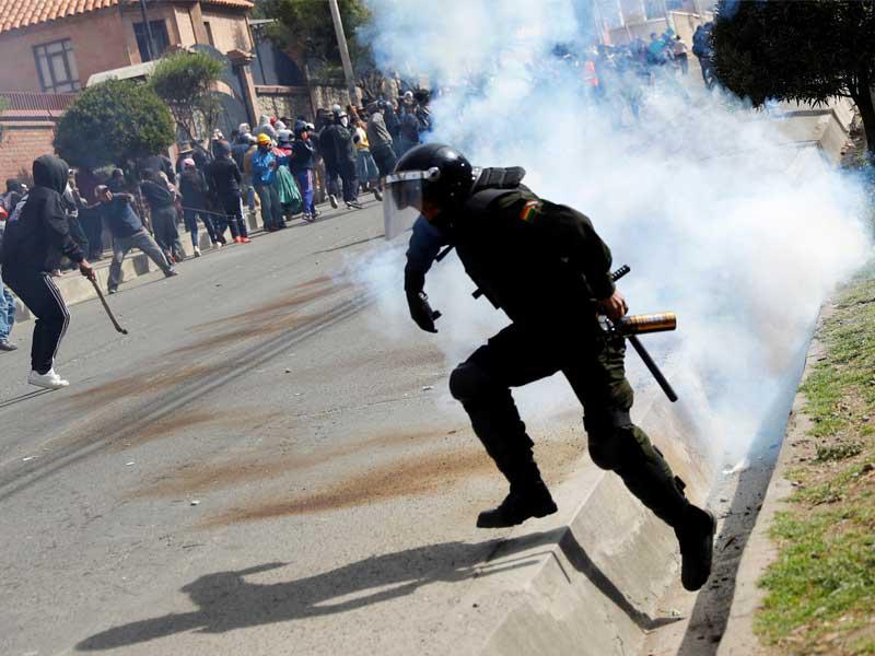 ضابط شرطة يستخدم الغاز المسيل للدموع ضد المتظاهرين خلال مظاهرة في لاباز ، بوليفيا