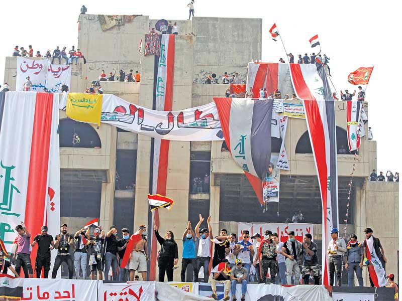 محتجون عراقيون في بغداد أمس (رويترز)