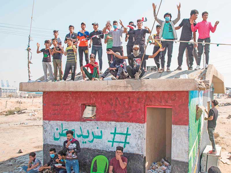 متظاهرون عراقيون على الطريق المؤدي إلى ميناء أم قصر أمس (أ ف ب)