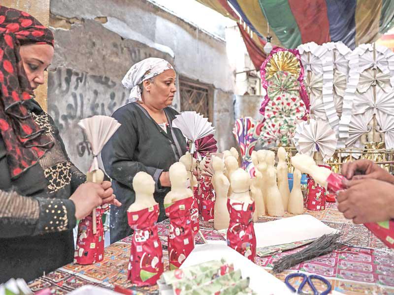 مصريتان تعدان حلويات بمناسبة اقتراب المولد النبوي الشريف الأسبوع المقبل (أ ف ب)