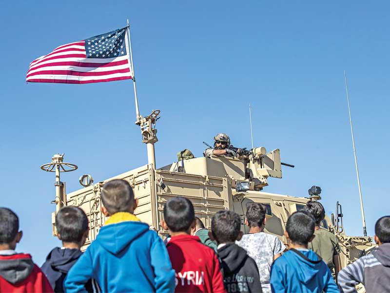 صبية يطالعون جندياً أميركياً خلال دورية مشتركة مع الوحدات الكردية بالحسكة أمس الأول   (أ ف ب)