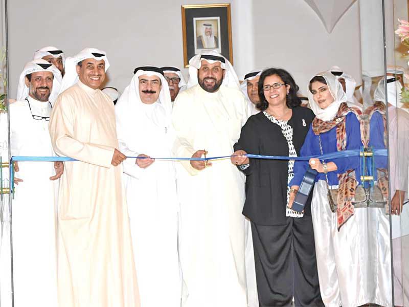 حمد جابر العلي وحرمه الشيخة عبير سالم العلي وكامل العبدالجليل والفنان الفوتوغرافي العميري أثناء قص شريط افتتاح المعرض