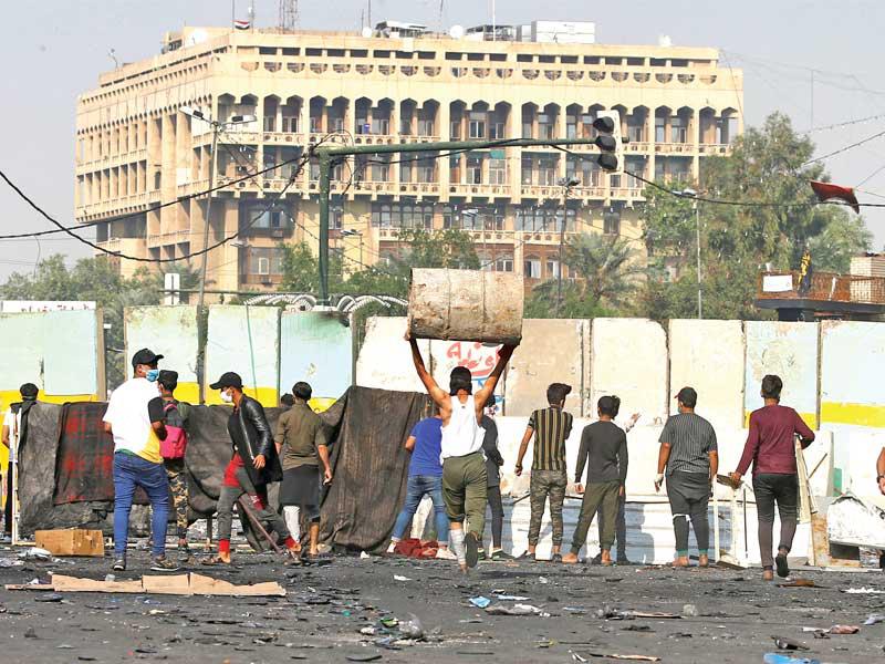 متظاهرون خلال مواجهات مع الأمن في بغداد أمس (رويترز)