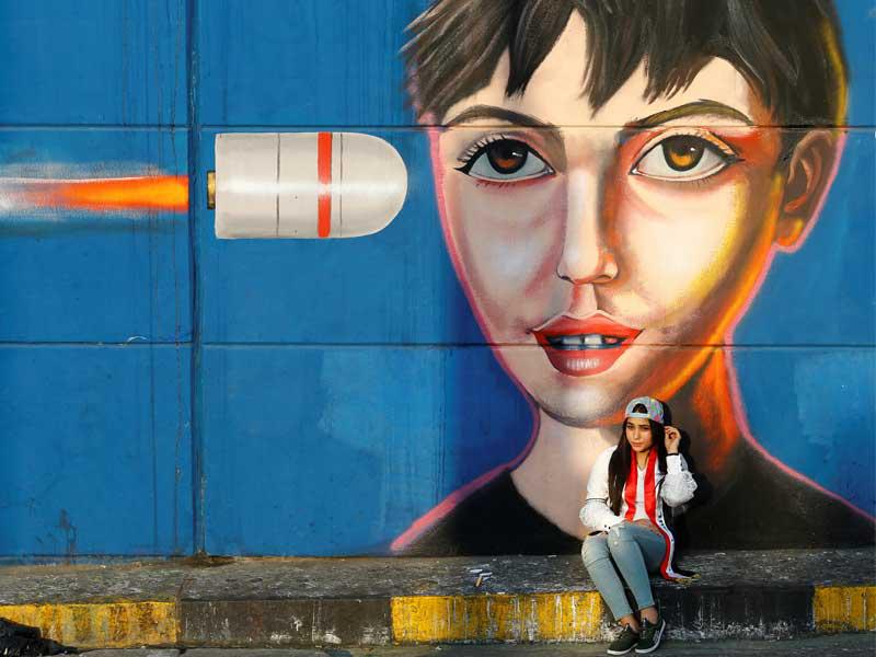 عراقية أمام جدارية في ساحة التحرير ببغداد أمس (رويترز)n