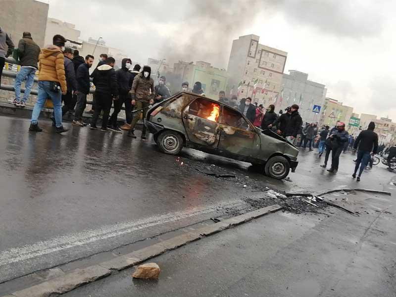 متظاهرون إيرانيون يحرقون سيارة في طهران أمس الأول (إي بي أيه)