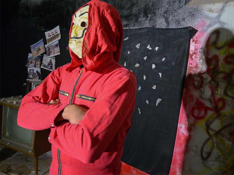 شاب عراقي يرتدي بذلة حمراء وقناع دالي لسلسلة لا كازا بابيل