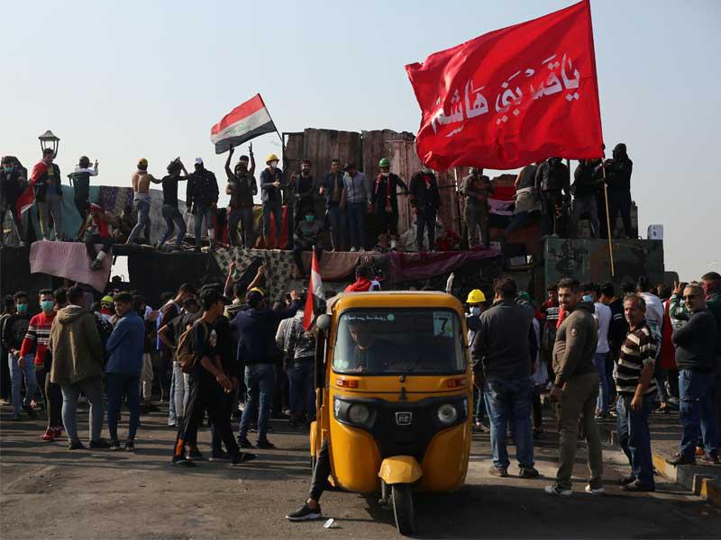 متظاهرون عند جسر الأحرار وسط بغداد أمس (رويترز)