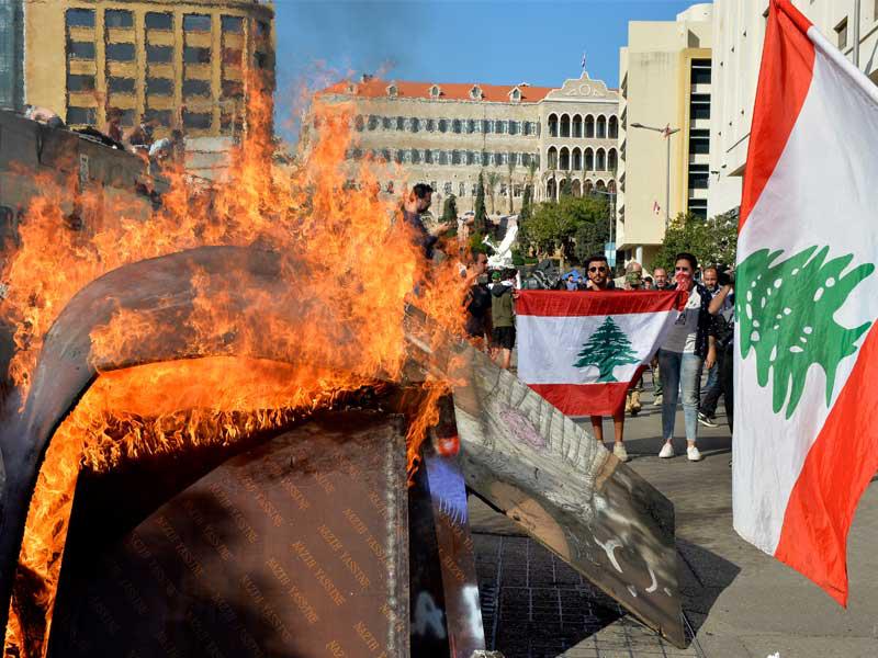 متظاهرون يحرقون مستوعباً للنفايات خلال محاصرتهم البرلمان لمنعه من الانعقاد أمس (إي بي أيه)n