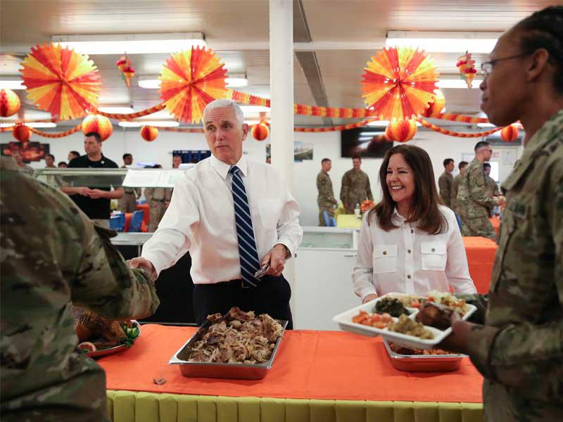 بنس وحرمه كارين يقدمان الطعام للجنود بمناسبة قرب «عيد الشكر» داخل قاعدة عين الأسد غرب العراق أمس   (رويترز)