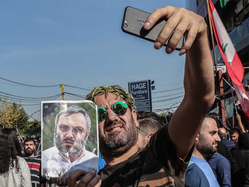 متظاهر يحمل صورة عماد مغنية  أمام السفارة الأميركية في عوكر أمس (أي بي أيه)