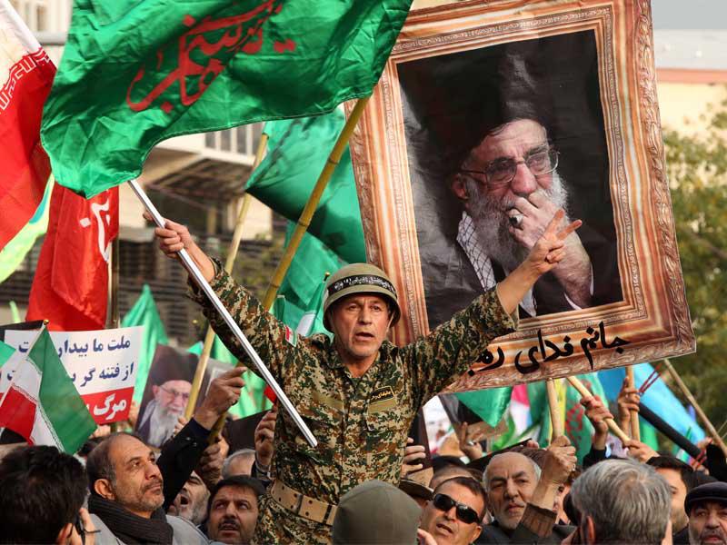 إيرانيون يحملون مقاتلاً خلال مسيرات موالية للنظام في طهران أمس (إي بي أيه)