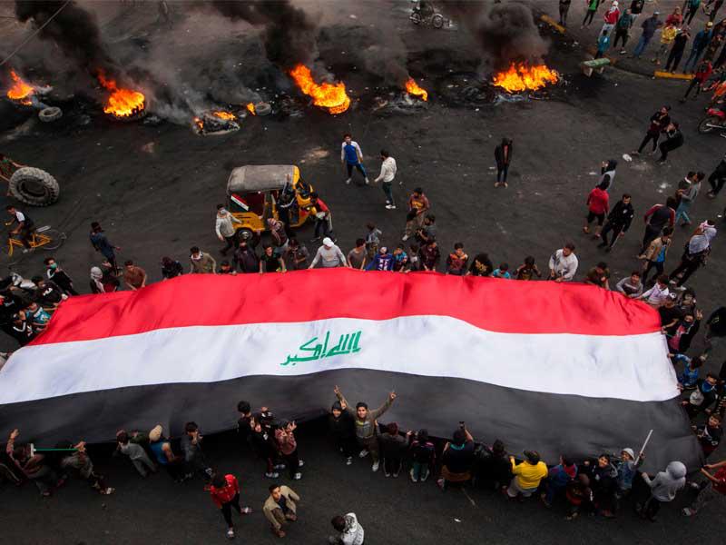 محتجون يقطعون طريقاً رئيسياً في البصرة أمس (أ ف ب)