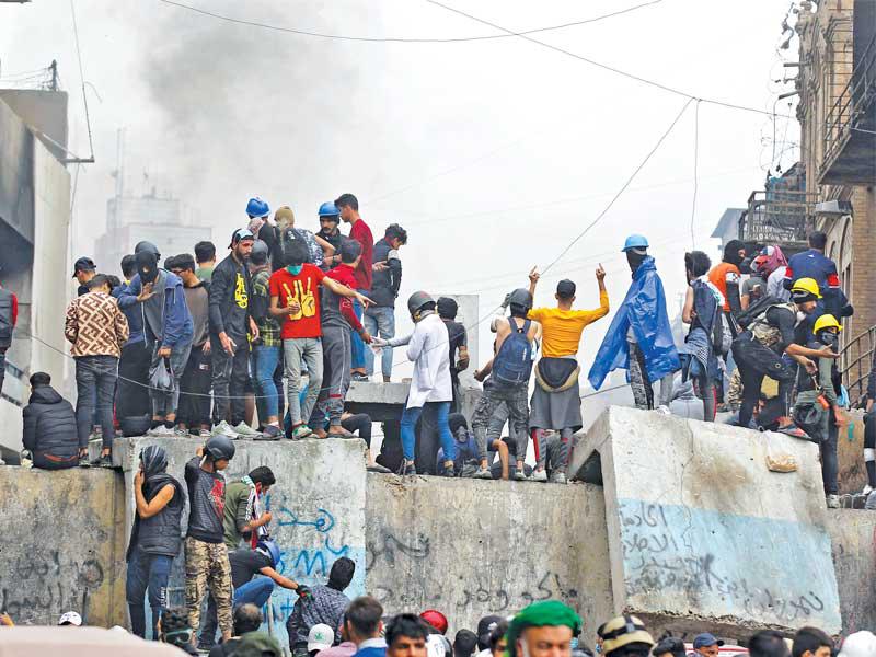 متظاهرون خلال مواجهات ببغداد أمس (أ ف ب)