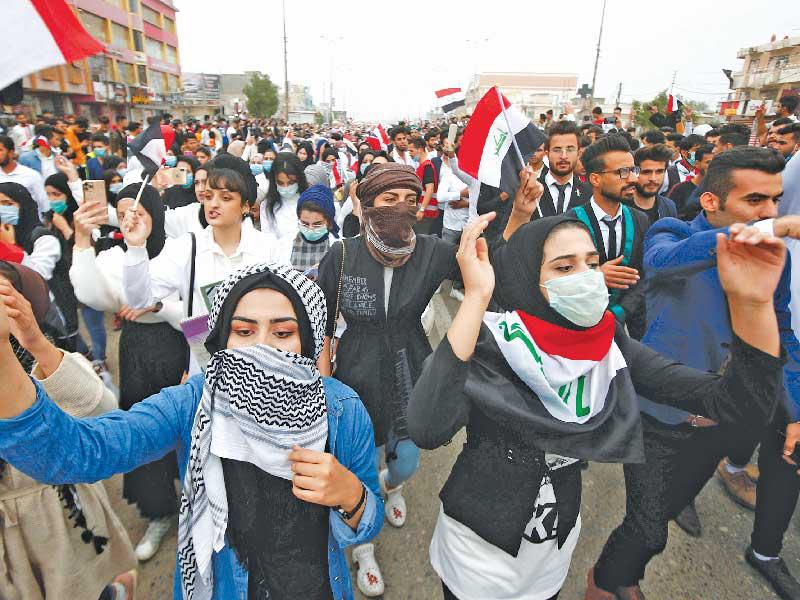 عراقيون وعراقيات من طلاب الجامعات خلال تظاهرة تطالب بالتغيير في البصرة أمس (رويترز)