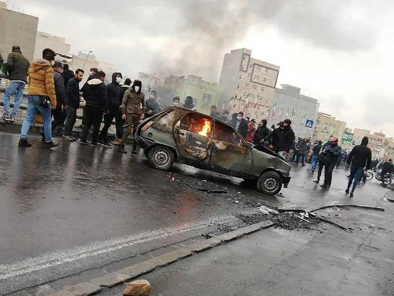 تجمع المحتجون الإيرانيون حول سيارة محترقة أثناء مظاهرة ضد زيادة أسعار البنزين في العاصمة طهران