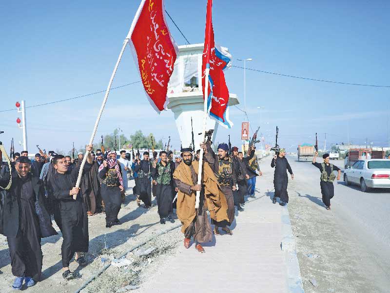 مسلحو عشائر كربلاء يطلقون الرصاص خلال مشاركتهم في مسيرة احتجاجية أمس (رويترز)