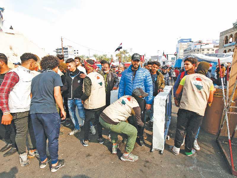 نقطة تفتيش أقامها المحتجون عند مداخل ساحات التظاهر وسط بغداد أمس (رويترز)