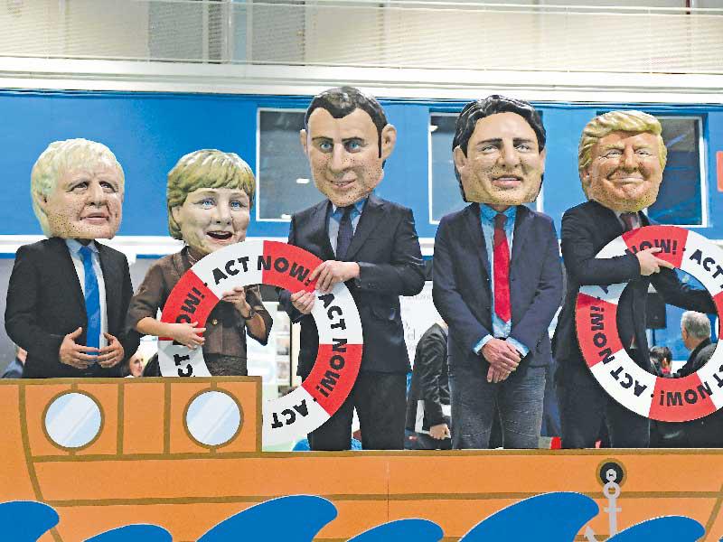  ناشطون يلبسون أقنعة تجسد الرئيسين الأميركي والفرنسي والمستشارة الألمانية ورئيسي وزراء كندا وبريطانيا خلال تظاهرة دفاعاً عن البيئة بمدريد (أ ف ب)