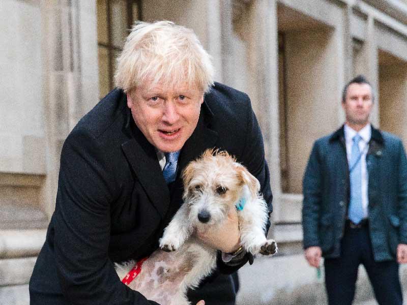 جونسون حاملاً كلبه «ديلين» بعد إدلائه بصوته أمس  (اي بي ايه)