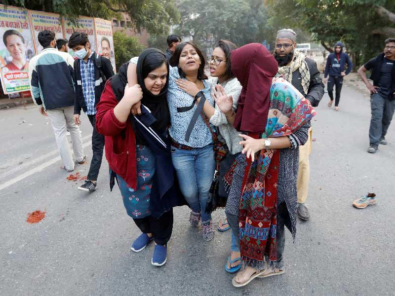 محاولة إسعاف سيدة أصيبت خلال تظاهرة ضد «قانون التجنيس» في نيودلهي أمس (رويترز)