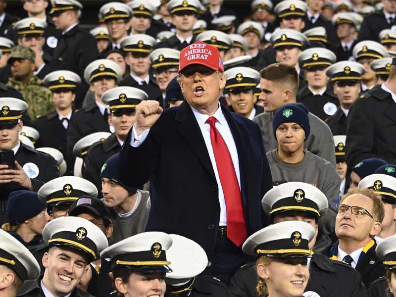 ترامب مشاركاً أمس الأول في مباراة كرة قدم بين الجيش والقوات البحرية في ملعب «لينكولن فاينانشيال فيلد» في فيلادلفيا                                                     (ا ف ب)