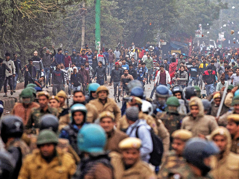 متظاهرون يرشقون الشرطة بالحجارة في دلهي أمس (رويترز)