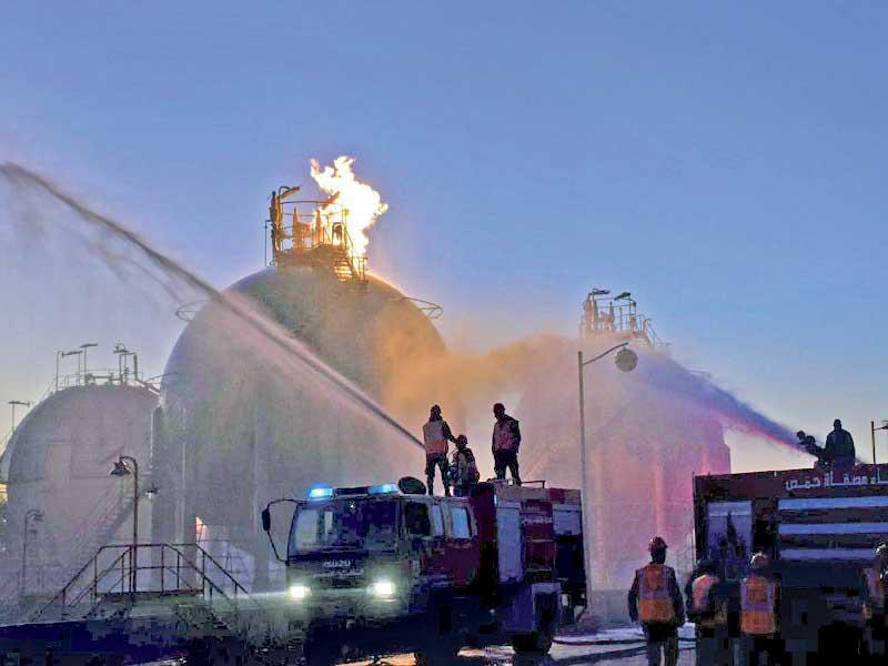 فرق إطفاء تحاول السيطرة على حريق مصفاة حمص أمس (أ ف ب)