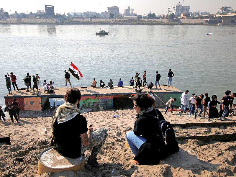 متظاهرون عراقيون على نهر دجلة في بغداد أمس (رويترز)