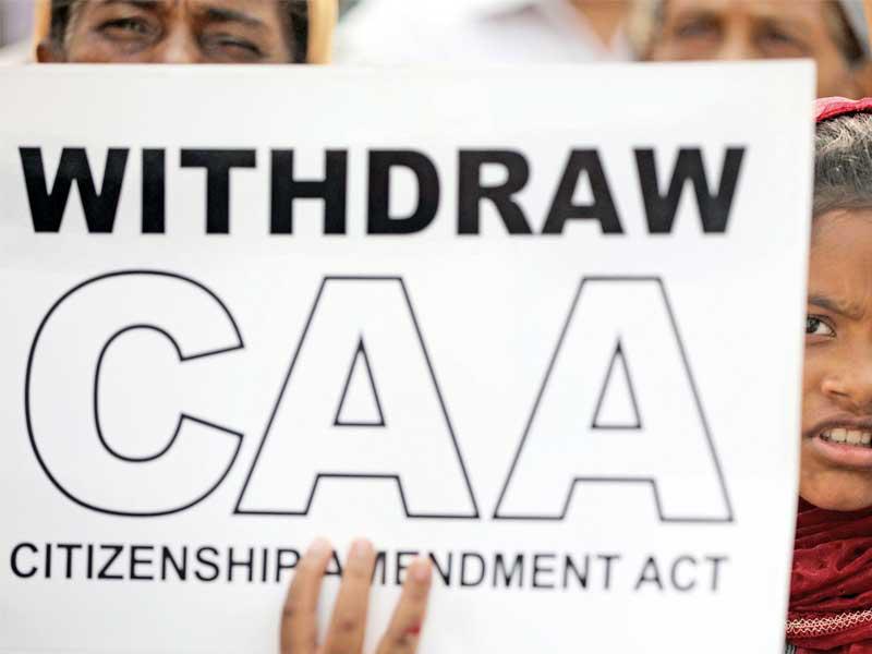 فتاة هندية تحمل لافتة تدعو لسحب قانون التجنيس الجديد في مدينة مومباي الهندية  (رويترز)