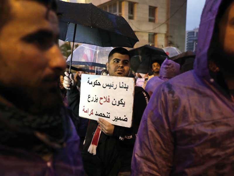 متظاهرون أمام منزل حسّان دياب مساء أمس الأول احتجاجاً على تكليفه تشكيل الحكومة             (أ ف ب)