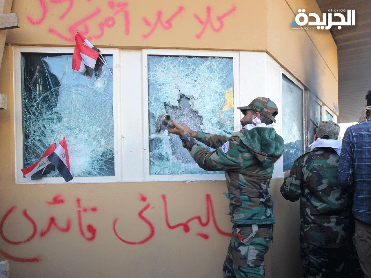 متظاهر من الحشد الشعبي يحطم نوافذ السفارة