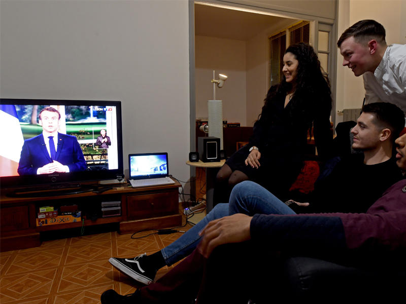 فرنسيون يتابعون كلمة ماكرون على التلفزيون مساء امس الأول (ا ف ب)