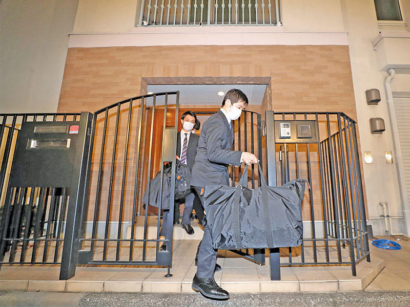 ممثلان عن الادعاء العام يغادران المنزل الذي كان يسكنه غصن في طوكيو بعد تفتيشه أمسt(أ ف ب)