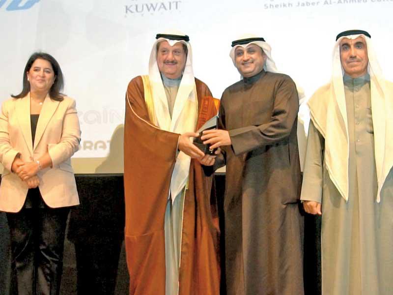 محمد الفارس يتسلم التكريم من عيسى الكندري بحضور رنا الفارس ود. حسين الأنصاري