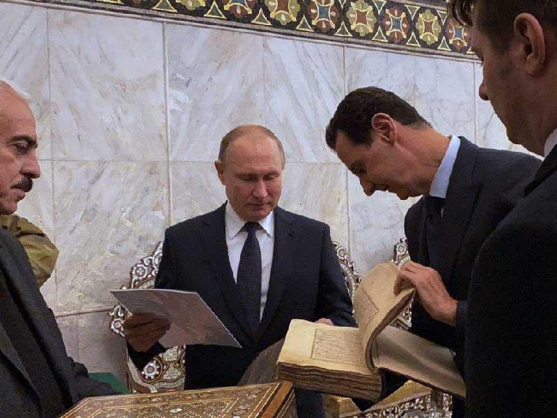 الأسد يطلع بوتين على مخطوطات المسجد الأموي بدمشق القديمة أمس (أ ف ب)n